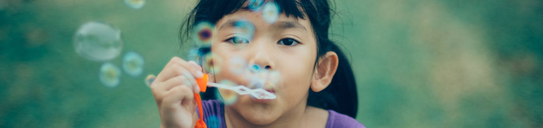 Image of young child blowing bubbles.